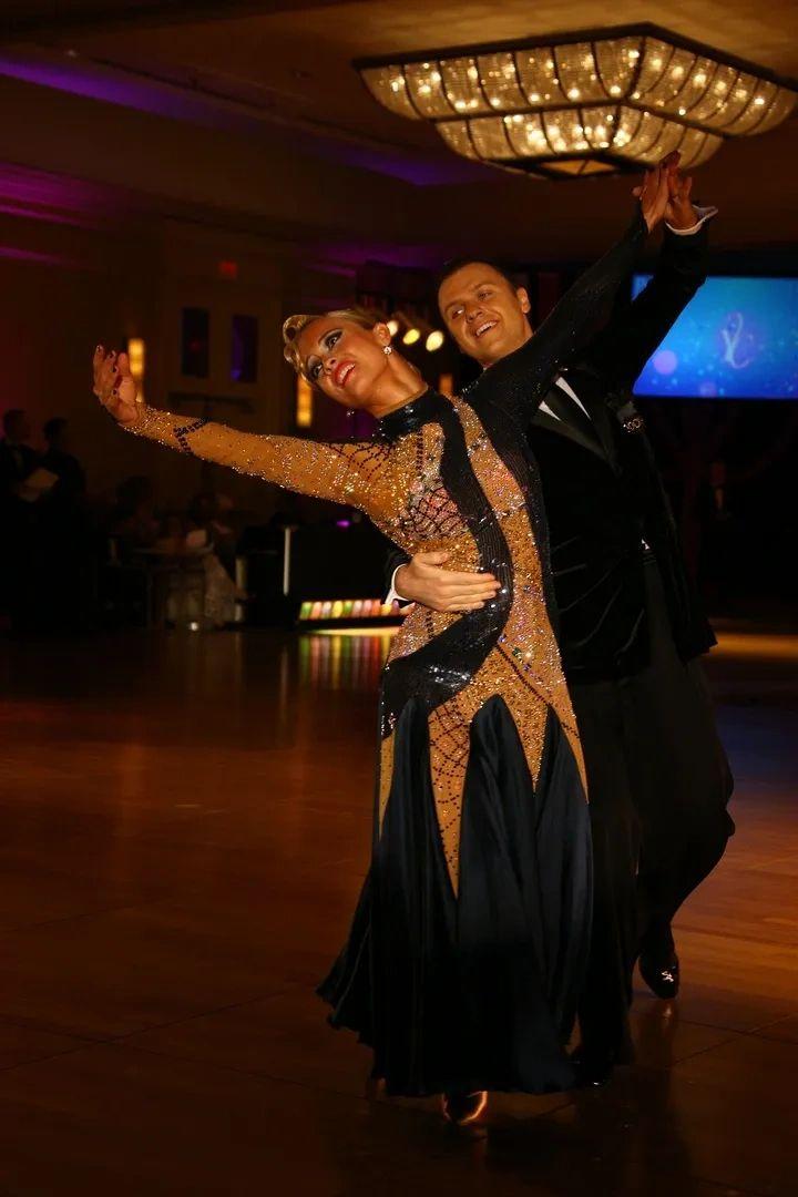 Slawomir Roszak dancing on a ballroom floor under chandeliers